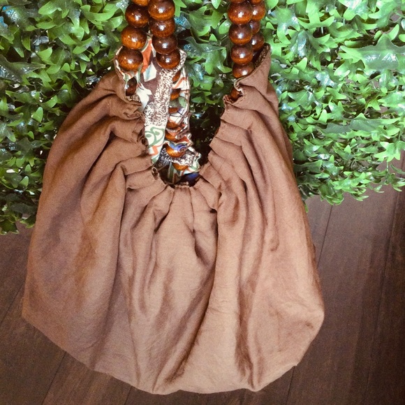 Reversible hobo tote with brown wood balls straps. Has a tie strap closure. - Picture 7 of 10